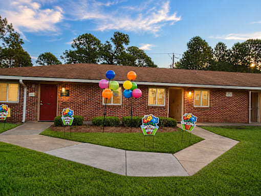 A house with a driveway and a sign that says "Welcome to Sunshine Elementary School".