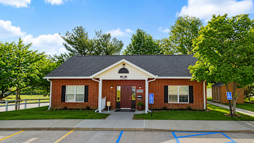 A small brick building with a brown door and windows.