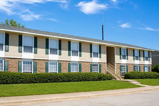 A building with a green lawn in front.