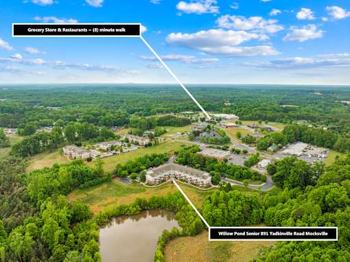 A bird's eye view of Willow Pond Senior Housing and a grocery store and restaurants 8 minutes away.