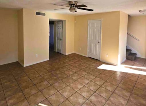 A room with tile flooring and a ceiling fan.