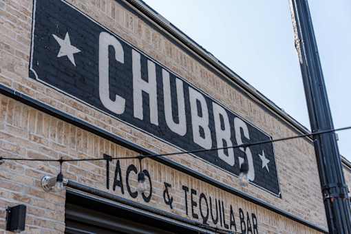 A brick building with a sign that says Chubbs Taco & Tequila Bar.
