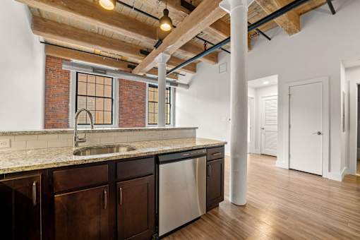 A kitchen with a brick wall and wooden beams.