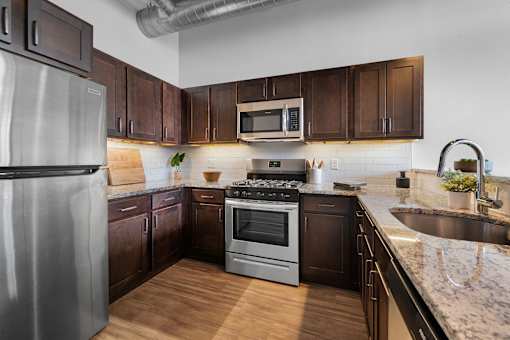 A kitchen with dark wood cabinets and stainless steel appliances.