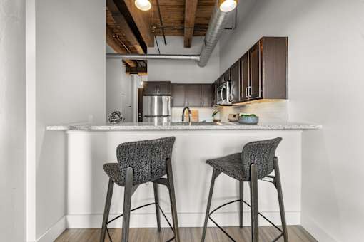 Two bar stools are placed in front of a kitchen island.