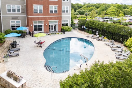 a swimming pool in a courtyard with a brick building