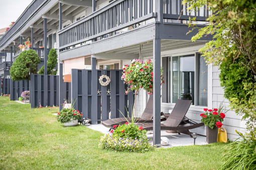 Bass point ground level apartments with patio and beach chairs with lawn overlooking harbor