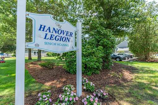 A sign for Hanover Legion Senior Housing stands in a landscaped area.