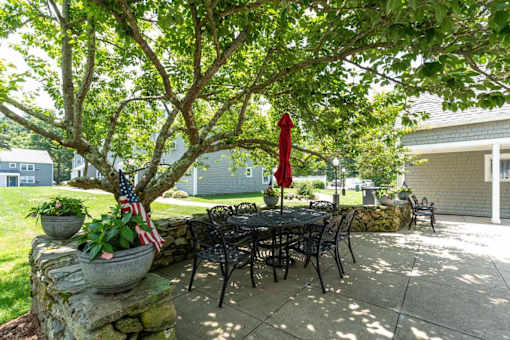 A patio with a table, chairs, and an American flag.