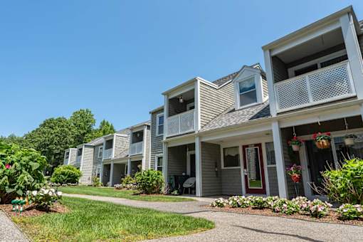 A row of townhouses with flower beds in front.