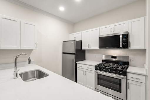 A kitchen with white cabinets and stainless steel appliances.