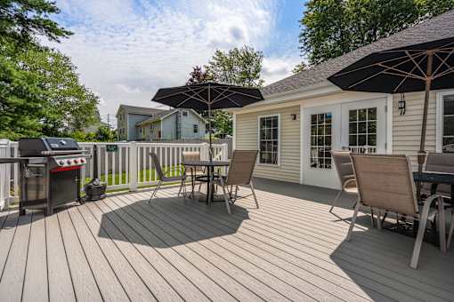 A wooden deck with chairs and an umbrella.