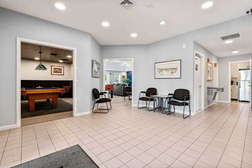 A spacious room with a pool table and chairs.