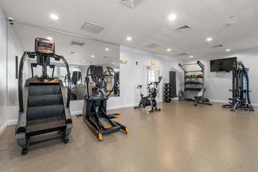 A gym with treadmills, exercise bikes, and other equipment.