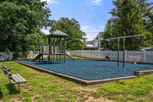 A playground with a slide, swings, and a playhouse.