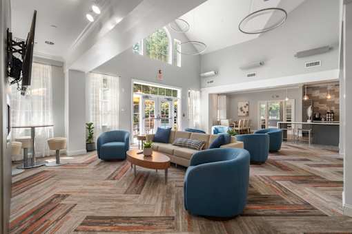 A spacious living room with a variety of seating options and a flat-screen TV.