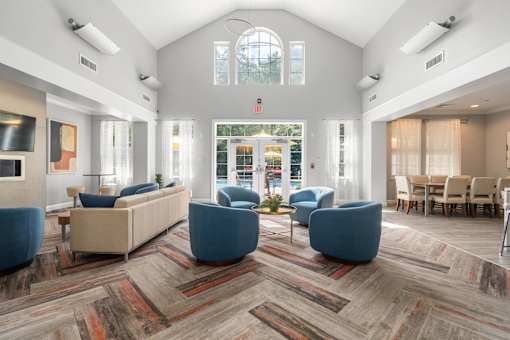 A spacious waiting room with blue chairs and a large window.