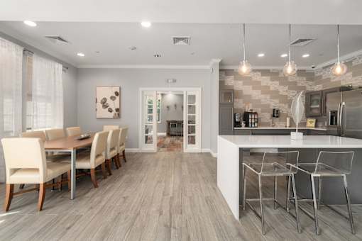 A modern kitchen and dining room with a wooden floor and white walls.