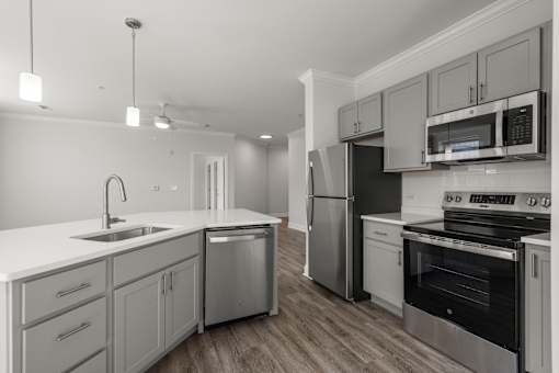 A modern kitchen with stainless steel appliances and wooden floors.
