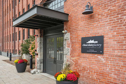 The entrance to a building with a sign that says Chocolate Factory Apartments.