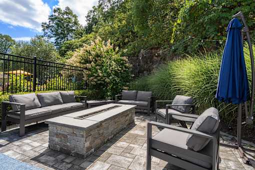 A patio with a stone table and chairs.