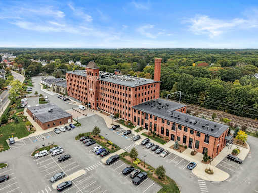 A large red brick building with a parking lot in front.
