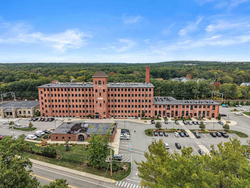 A large red brick building with a parking lot in front.