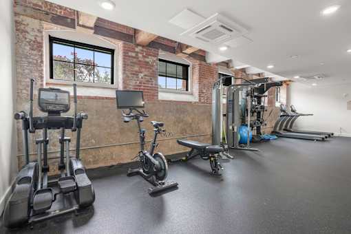 A gym with a brick wall and various exercise equipment.