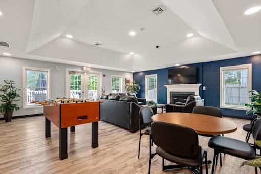 A room with a foosball table and a fireplace.