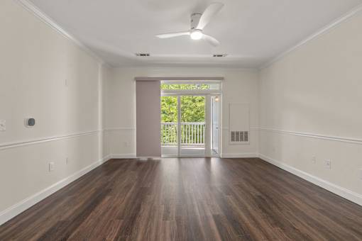 A room with wooden floors and a ceiling fan.