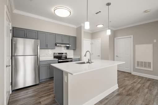 A modern kitchen with a large island and stainless steel appliances.