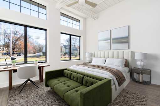 A bedroom with a large bed and a green couch.