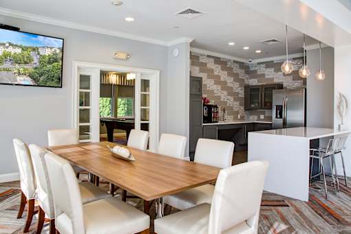A modern dining room with a wooden table and white chairs.