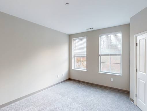 A room with two windows and a door.