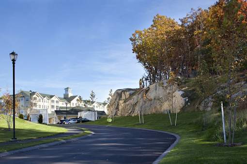 A street with a lamp post and a house in the background.