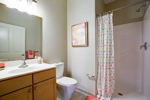 A bathroom with a toilet, sink, and shower.
