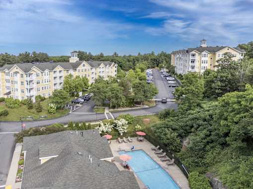 A large apartment complex with a pool and a parking lot.