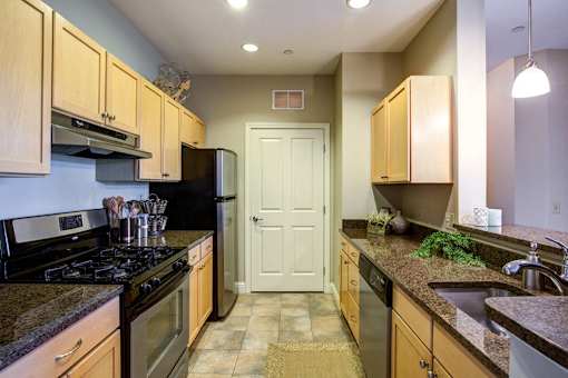 A kitchen with wooden cabinets and granite countertops.
