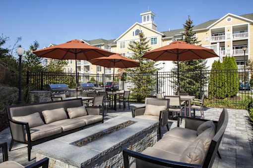A patio with a table and chairs and umbrellas.
