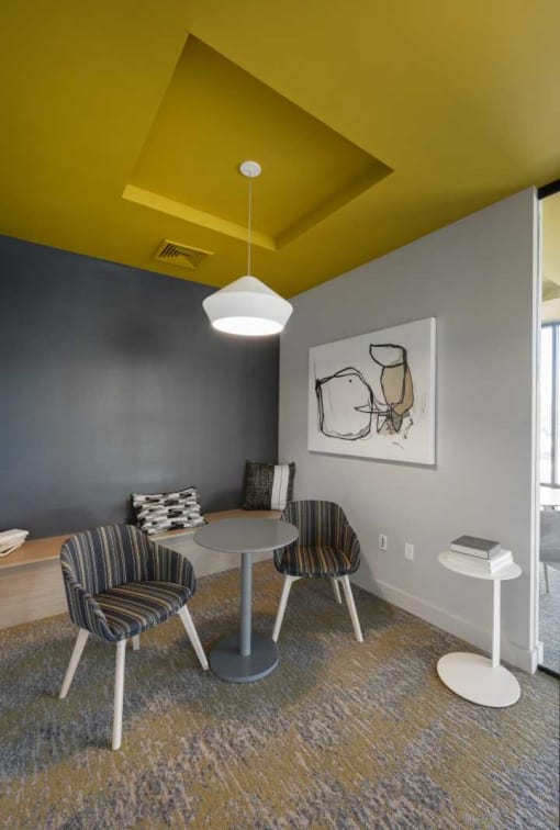 a dining room with a yellow ceiling and gray walls