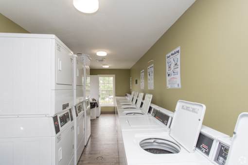 A laundry room with rows of washers and dryers.