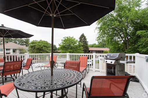 A patio with a table and chairs under an umbrella.