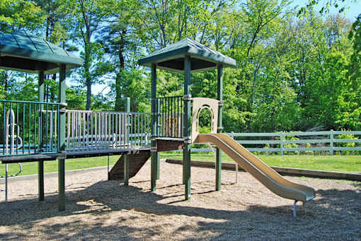 A playground with a slide and two gazebos.