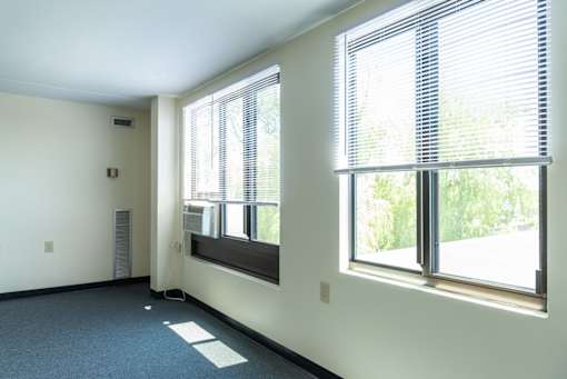 A room with a window and a wall-mounted speaker.