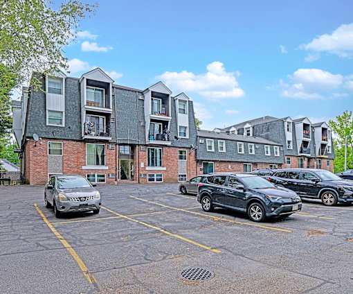A parking lot with cars and a building in the background.