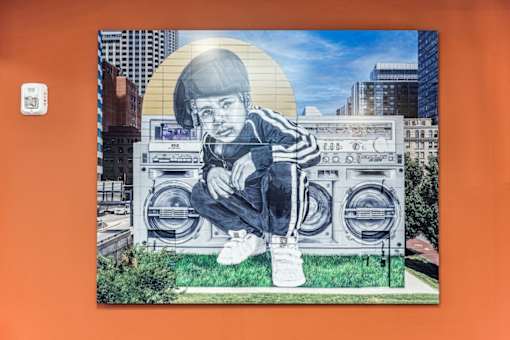 A mural of a person sitting on a boombox.