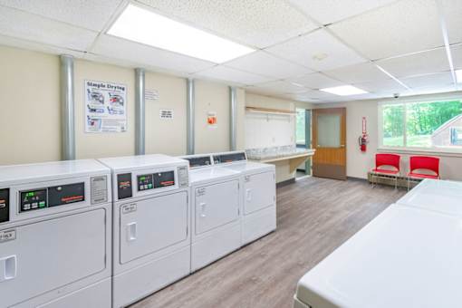 A laundry room with washing machines and a sign that says "Simple Drive".
