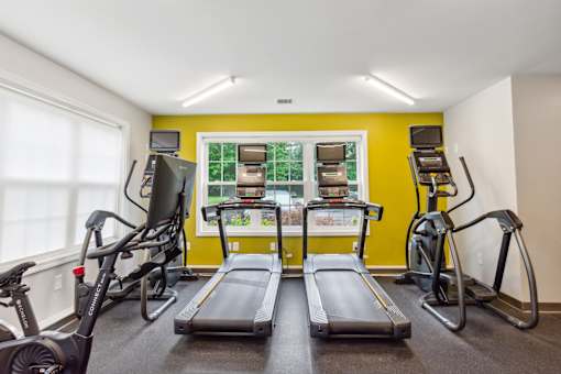 Community Fitness Center with treadmill and exercise bikes  at Station Pointe Apartments, Mansfield, MA, 02048two treadmills and weights in a gym with a window