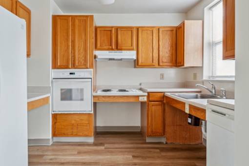 a kitchen with wooden cabinets and white appliances at Monterey Place, New Haven, CT, 06511