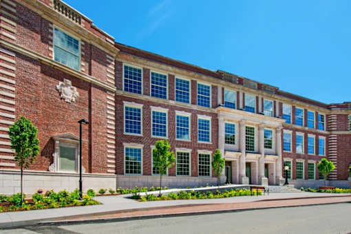 a large brick building with many windows and a street in front at Beverly Village for Living & the Arts Apartments, Beverly, 01915